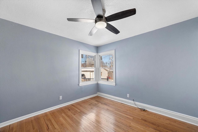 unfurnished room featuring a ceiling fan, a textured ceiling, baseboards, and wood finished floors