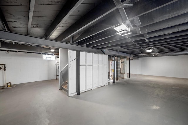 basement with gas water heater and stairs