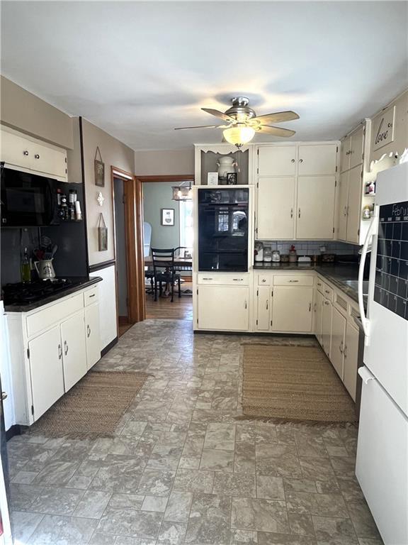 kitchen with tasteful backsplash, dark countertops, black appliances, and a ceiling fan