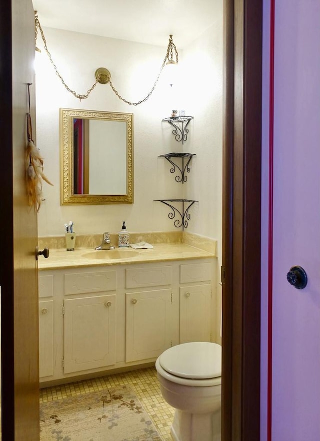 half bath featuring toilet, vanity, and tile patterned floors