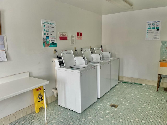 community laundry room with light tile patterned floors and washing machine and dryer