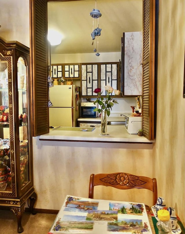 kitchen featuring freestanding refrigerator and a sink