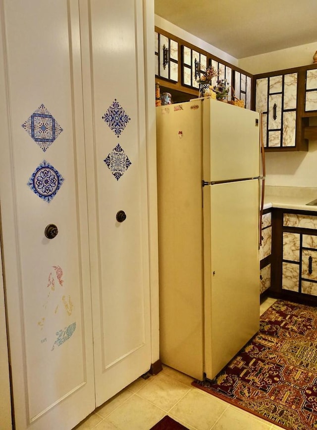 kitchen featuring light tile patterned floors and freestanding refrigerator