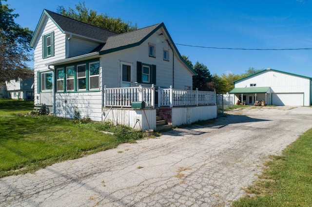 14034 58th Rd, Sturtevant, WI 53177 - view of front facade with a shingled roof, a detached garage, and a front yard