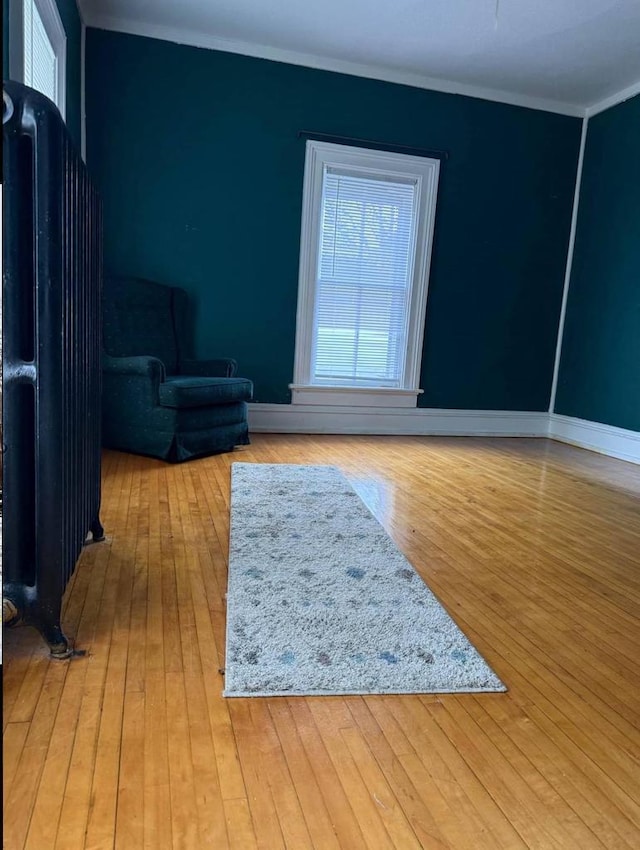 interior space with baseboards, ornamental molding, and hardwood / wood-style floors