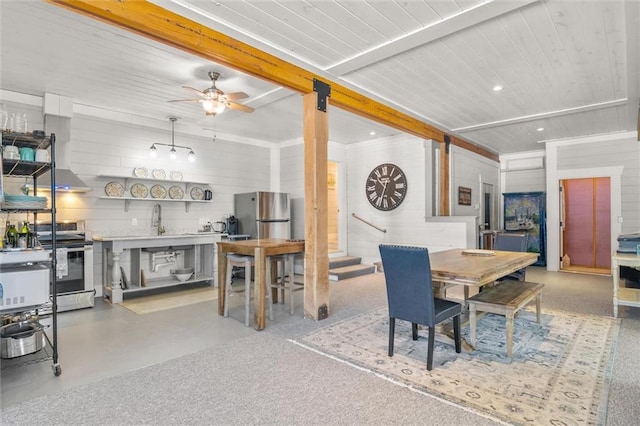 dining area featuring wood walls, ceiling fan, beam ceiling, and recessed lighting