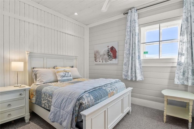 carpeted bedroom with wood walls