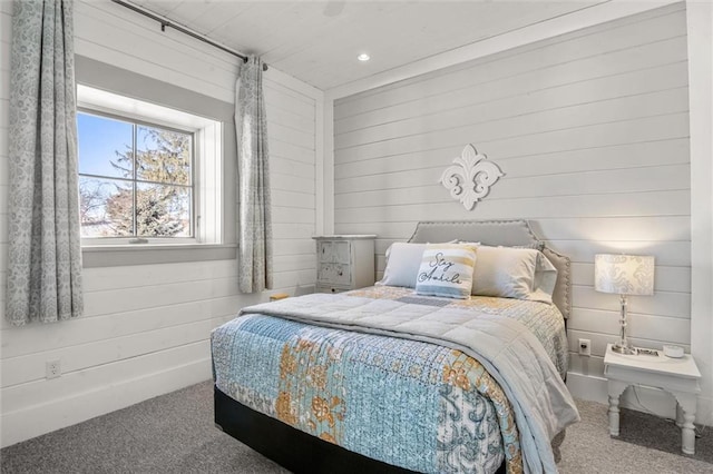 bedroom featuring wood walls and carpet