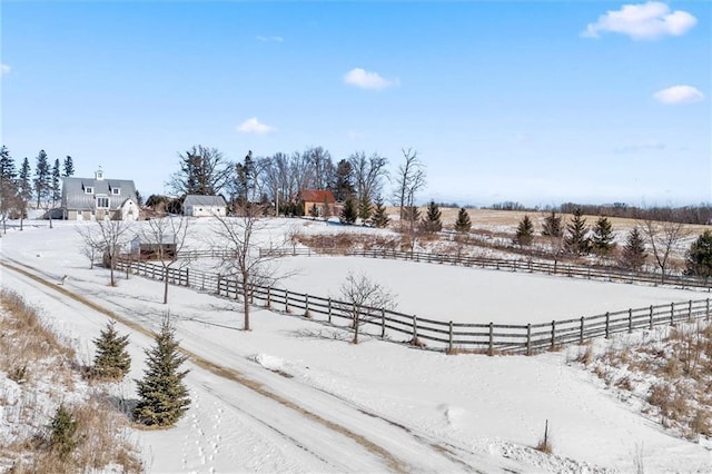 yard covered in snow featuring fence and a rural view