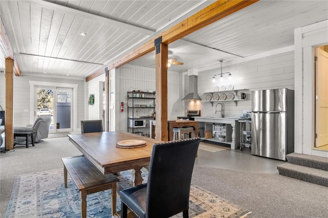 dining room with carpet, wooden ceiling, and beamed ceiling