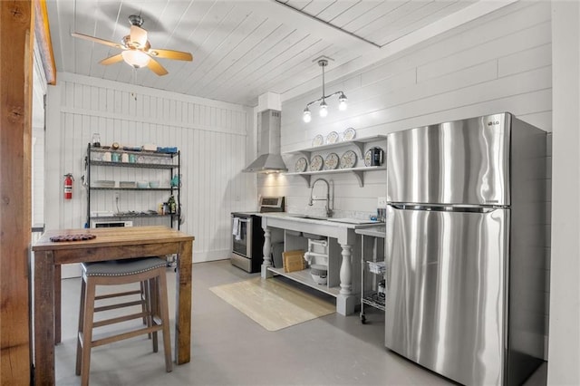 kitchen featuring open shelves, appliances with stainless steel finishes, a sink, concrete flooring, and wall chimney exhaust hood