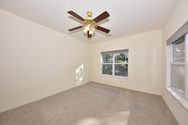 unfurnished room with baseboards, a ceiling fan, and light colored carpet