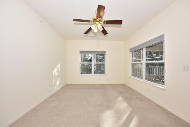 spare room featuring ceiling fan, baseboards, and light colored carpet