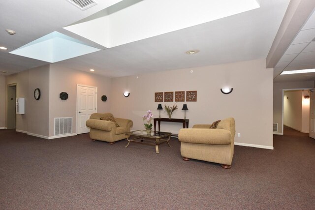 living area with baseboards, visible vents, and dark colored carpet