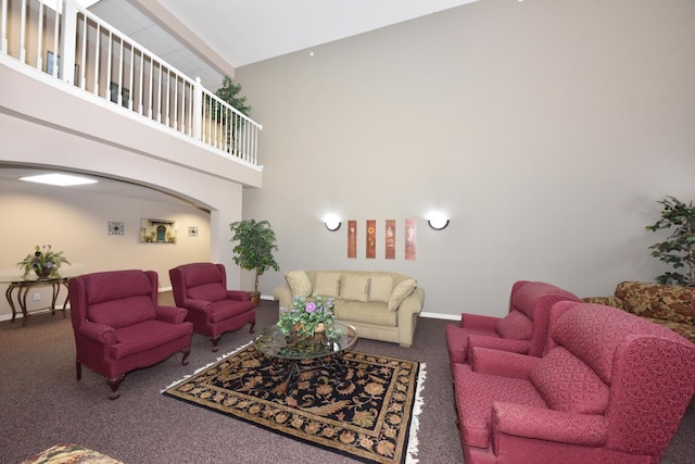 living area with carpet floors, arched walkways, baseboards, and a high ceiling