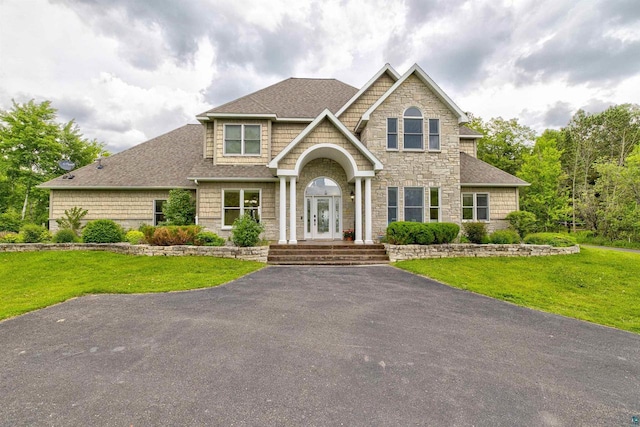 7926 S County Rd A, Superior, WI 54880 - view of front of property with stone siding, a front yard, and a shingled roof