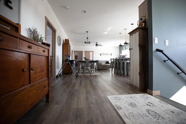 corridor featuring dark wood-style floors and an upstairs landing