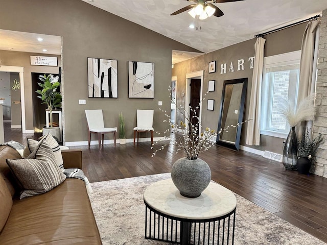 living area featuring lofted ceiling, hardwood / wood-style flooring, a ceiling fan, visible vents, and baseboards