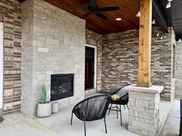 view of patio / terrace with a fireplace and a ceiling fan