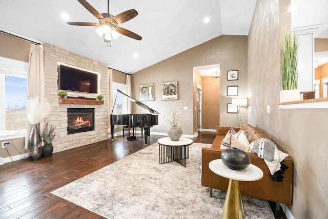 living area featuring a fireplace, vaulted ceiling, baseboards, and hardwood / wood-style flooring