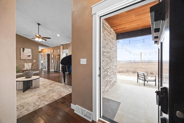 interior space featuring baseboards, visible vents, lofted ceiling, hardwood / wood-style flooring, and wooden ceiling