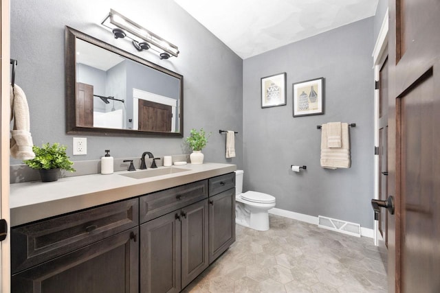 full bath with toilet, vanity, visible vents, baseboards, and a shower