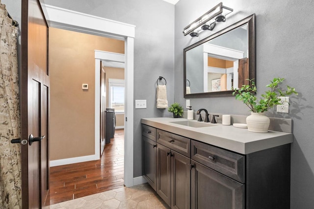 bathroom with vanity, baseboards, and wood finished floors