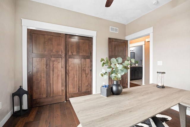 office space with dark wood-style flooring, visible vents, and ceiling fan