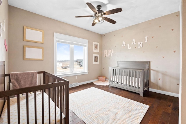 bedroom with a ceiling fan, wood-type flooring, visible vents, and baseboards