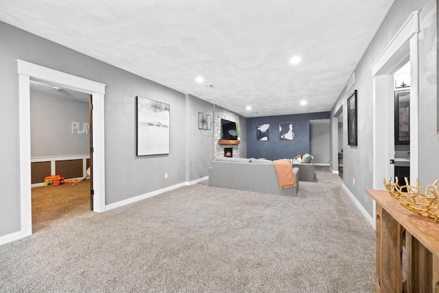 living area featuring recessed lighting, a fireplace, carpet flooring, and baseboards