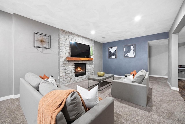 living area featuring carpet, a stone fireplace, and baseboards