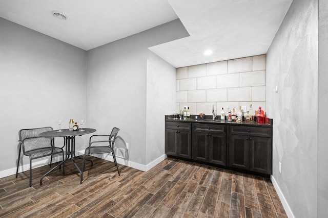 bar featuring a dry bar, baseboards, and dark wood finished floors