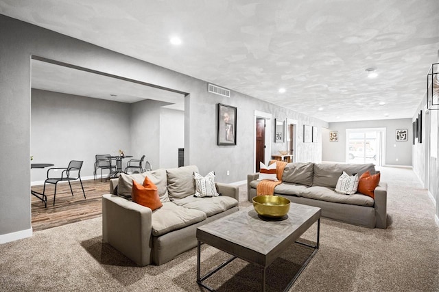 carpeted living room featuring baseboards, visible vents, and recessed lighting