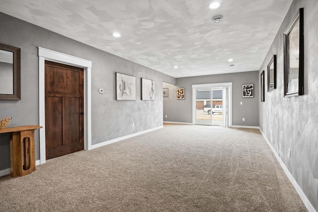 unfurnished living room with recessed lighting, carpet flooring, and baseboards