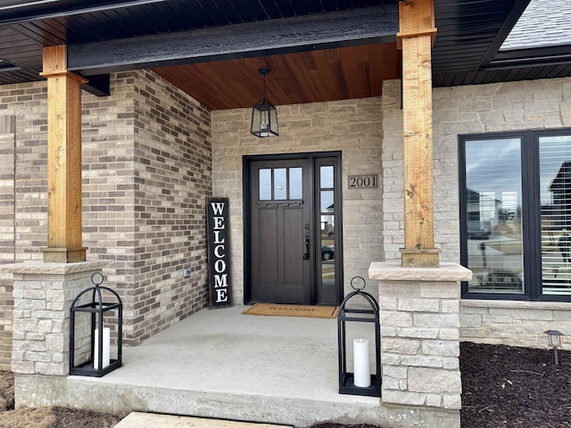 doorway to property with stone siding and brick siding