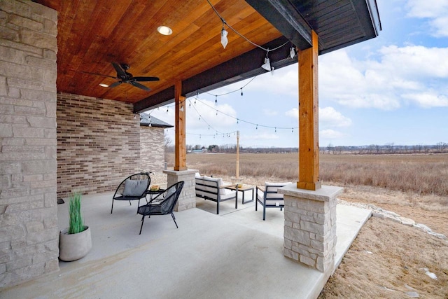 view of patio with ceiling fan and a rural view