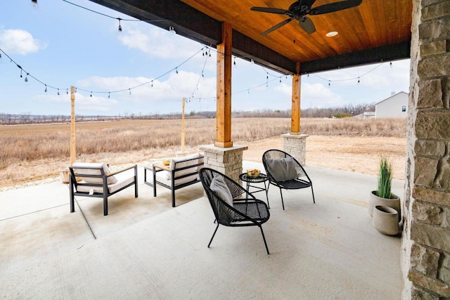 view of patio featuring ceiling fan and a rural view