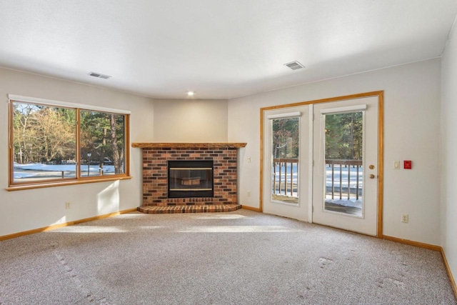 unfurnished living room with baseboards, visible vents, and carpet flooring