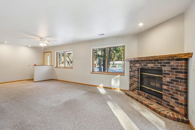 unfurnished living room with carpet, visible vents, a fireplace, and baseboards