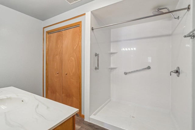 full bath with a shower stall and vanity