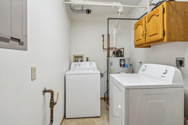 clothes washing area featuring water heater, cabinet space, electric panel, and washer and clothes dryer