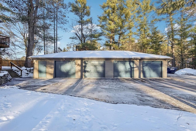 snow covered garage featuring a garage