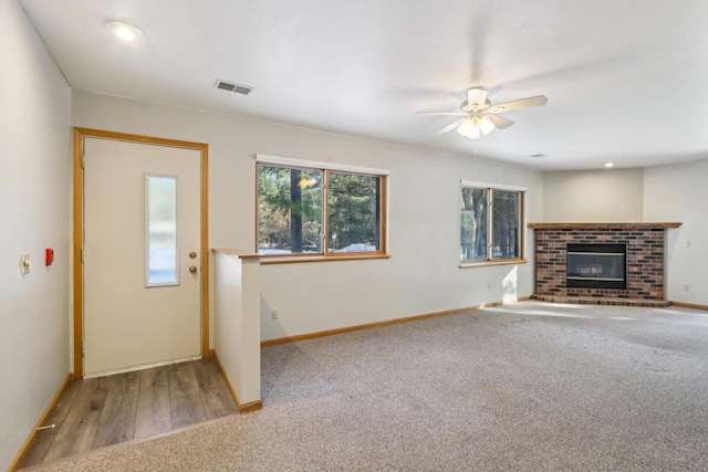 unfurnished living room featuring a fireplace, visible vents, and baseboards