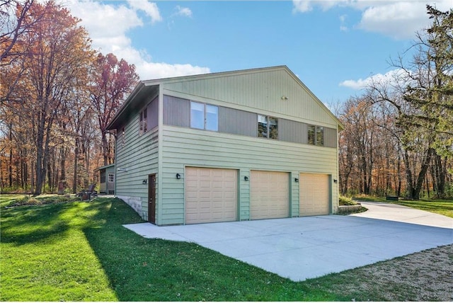 view of side of home featuring a garage, a lawn, and concrete driveway