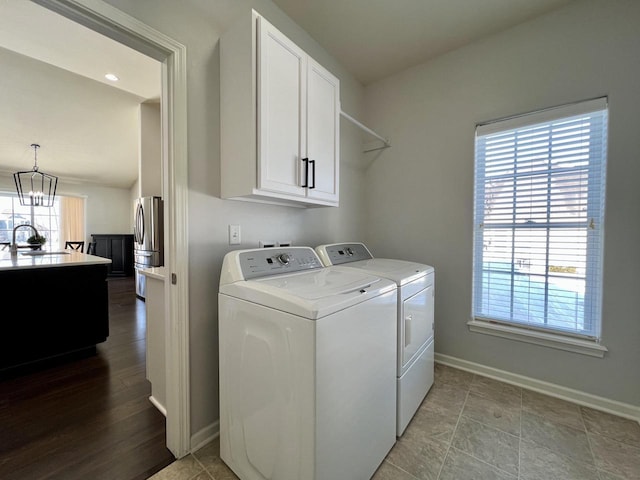 laundry area with plenty of natural light, washing machine and dryer, cabinet space, and a sink