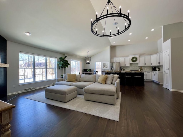 living area with visible vents, dark wood-style flooring, and a notable chandelier