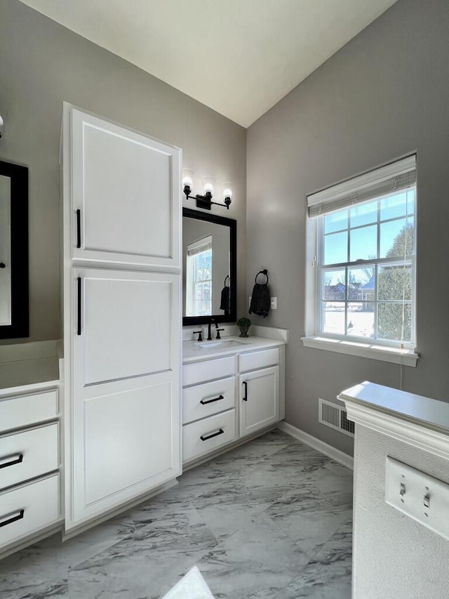 bathroom featuring marble finish floor, vanity, visible vents, and baseboards