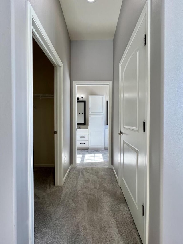 hallway with carpet flooring and baseboards