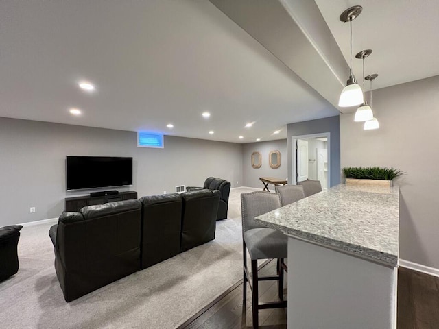 living area with baseboards, dark carpet, and recessed lighting