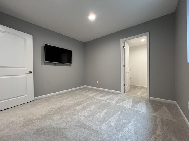 spare room with light carpet and baseboards